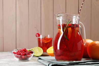 Photo of Tasty punch drink and ingredients on white table