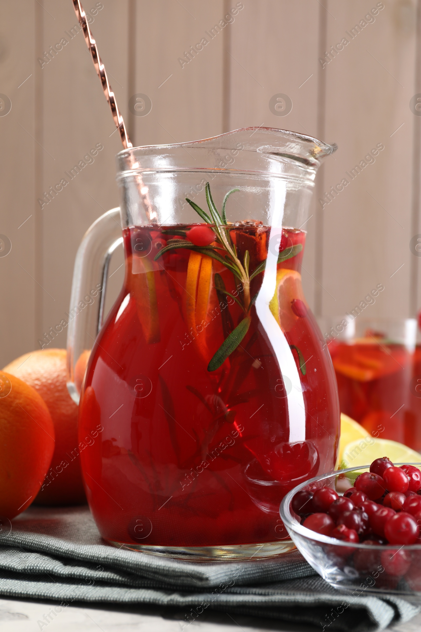 Photo of Tasty punch drink in glass jug and ingredients on table, closeup