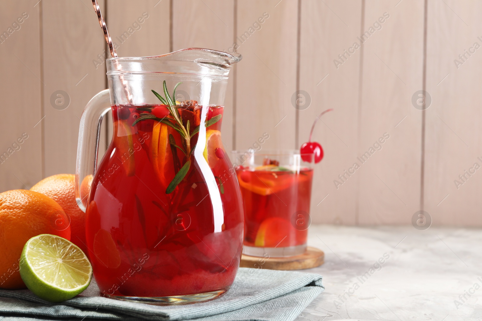 Photo of Tasty punch drink and ingredients on white table, space for text