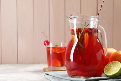 Photo of Tasty punch drink and ingredients on white table, space for text