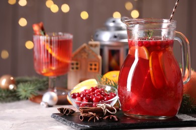 Photo of Tasty punch drink in glass jug, ingredients and Christmas decor on white table, space for text