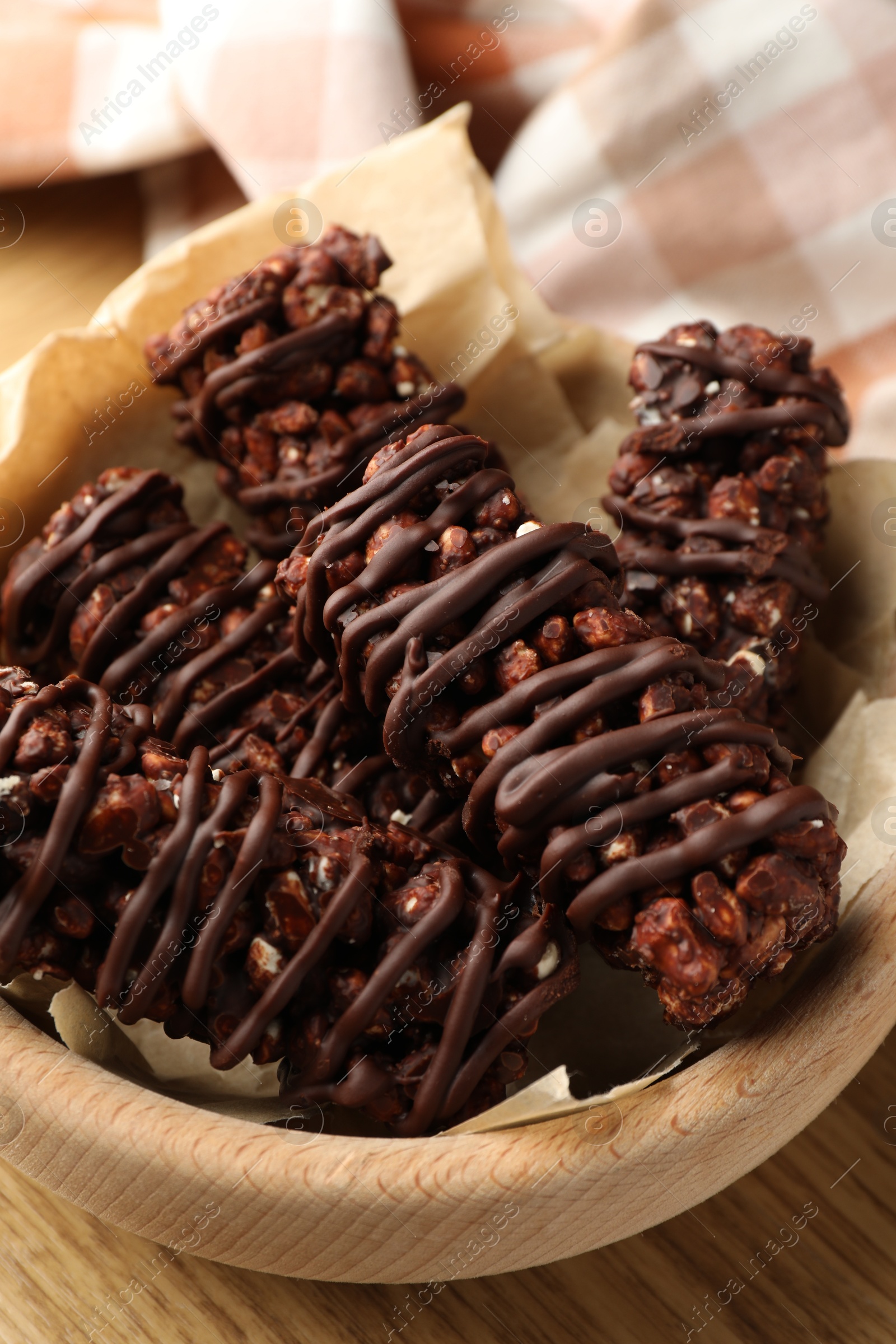 Photo of Delicious chocolate puffed rice bars on wooden table, closeup