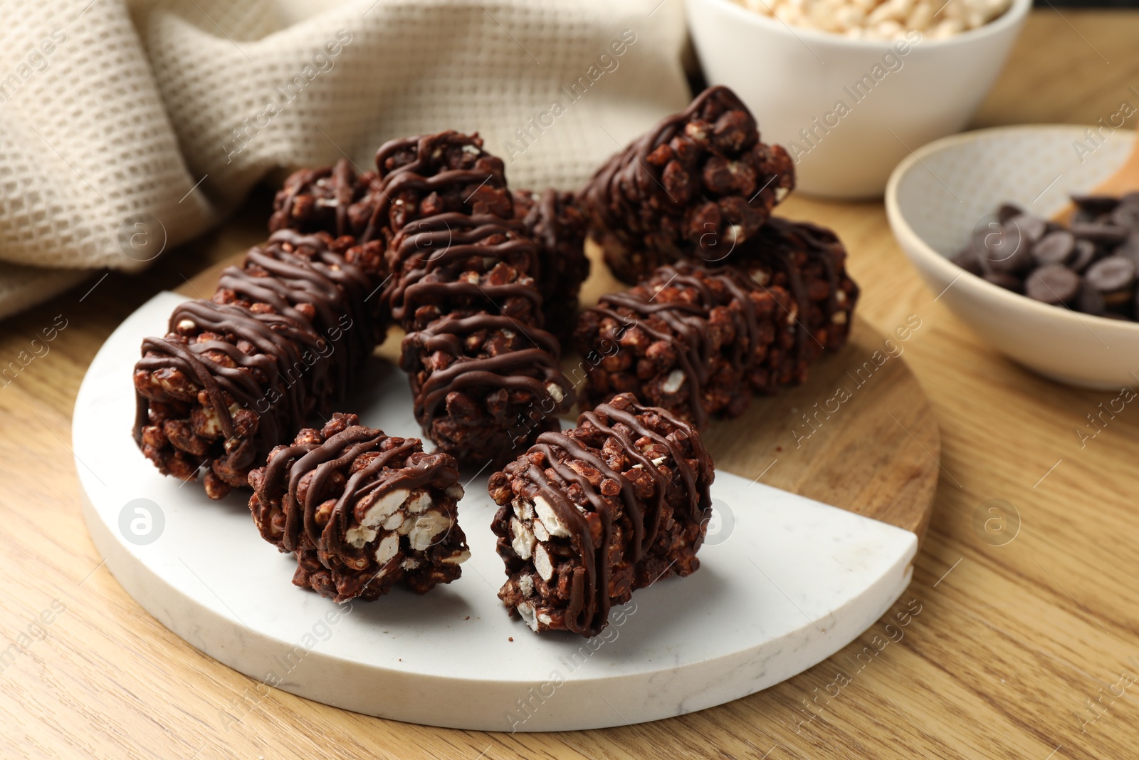 Photo of Delicious chocolate puffed rice bars on wooden table, closeup