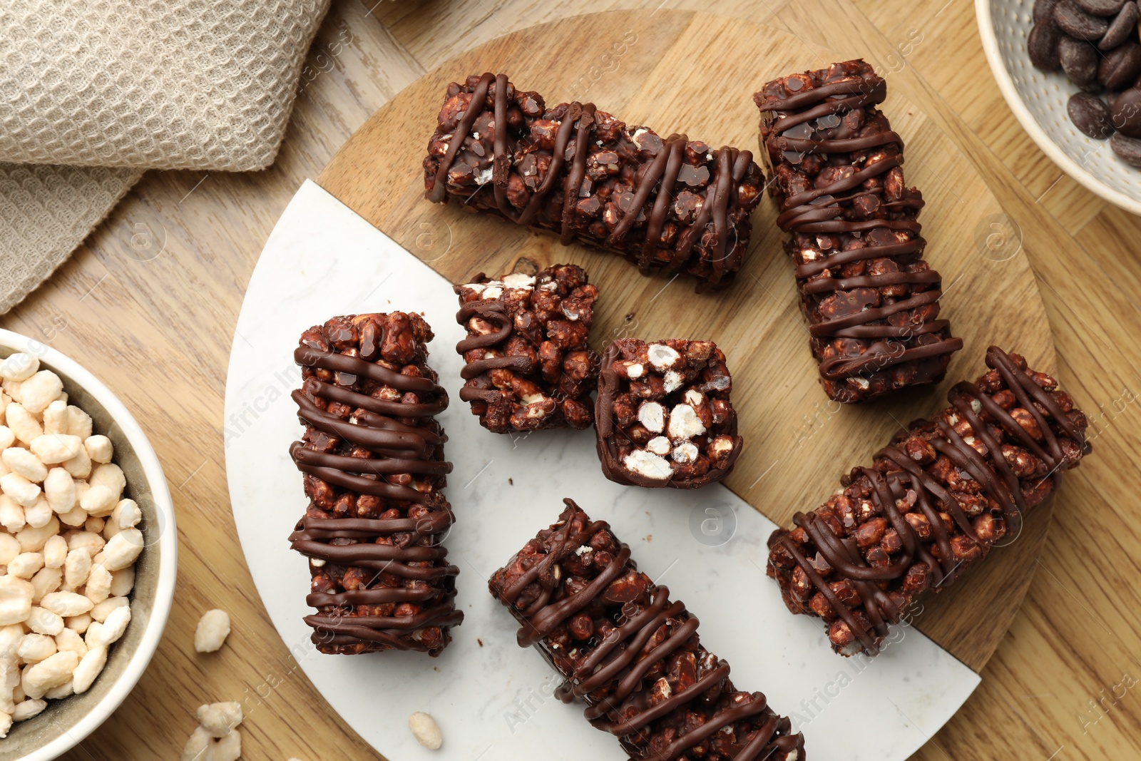 Photo of Delicious chocolate puffed rice bars on wooden table, flat lay