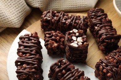 Photo of Delicious chocolate puffed rice bars on wooden table, closeup