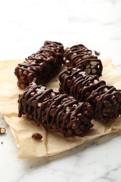 Photo of Delicious chocolate puffed rice bars on white marble table, closeup