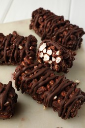 Photo of Delicious chocolate puffed rice bars on white wooden table, closeup