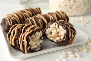 Photo of Delicious chocolate puffed rice bars on white wooden table, closeup