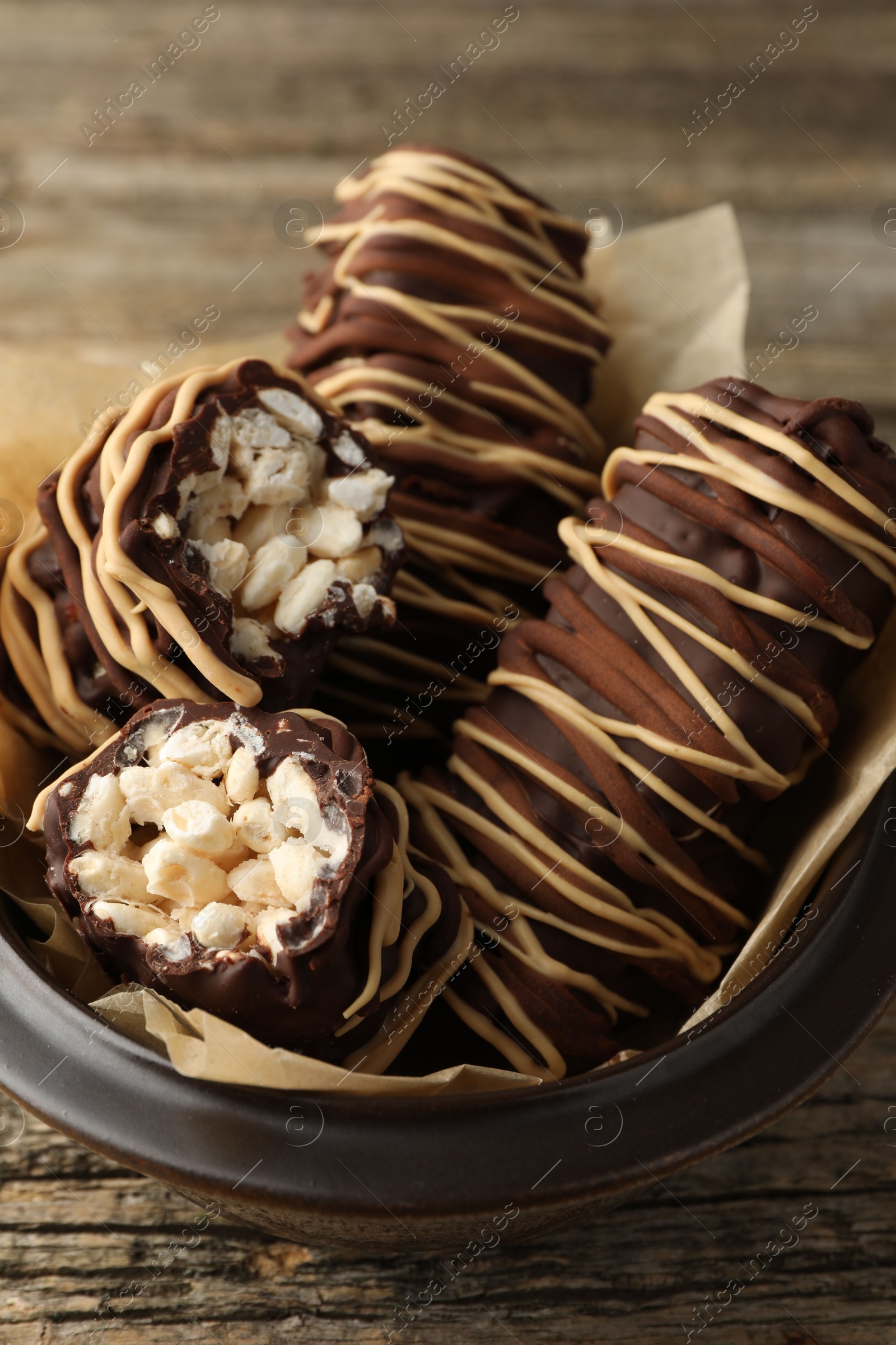 Photo of Delicious chocolate puffed rice bars on wooden table, closeup