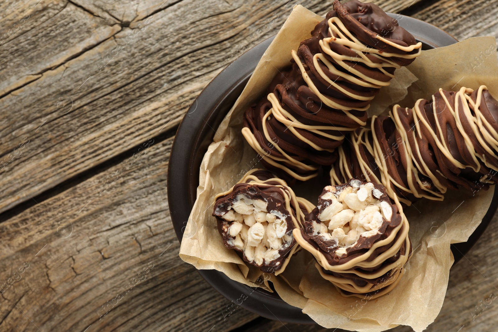 Photo of Delicious chocolate puffed rice bars on wooden table, top view. Space for text