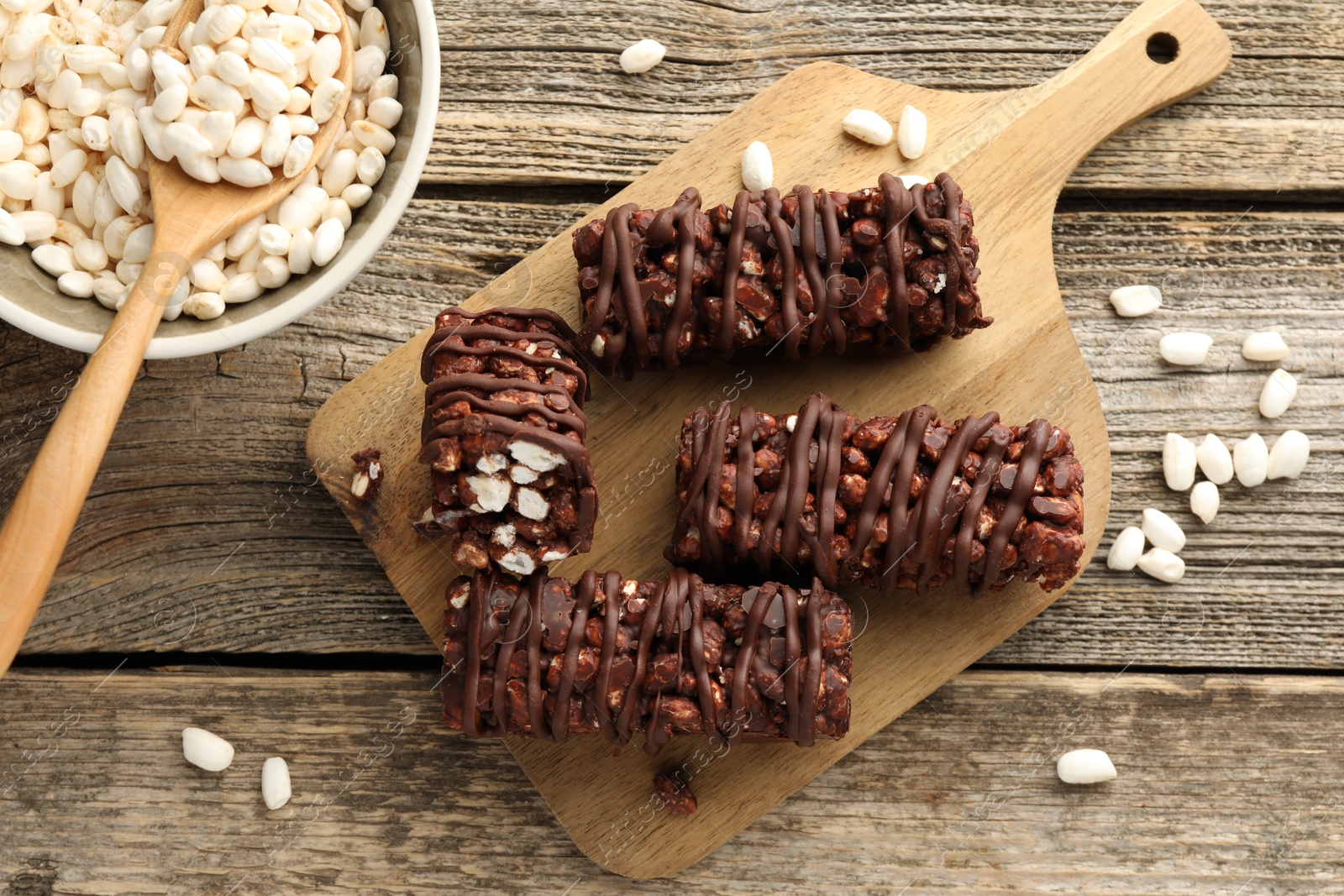 Photo of Delicious chocolate puffed rice bars on wooden table, flat lay