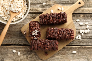 Photo of Delicious chocolate puffed rice bars on wooden table, flat lay