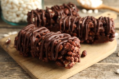 Delicious chocolate puffed rice bars on wooden table, closeup