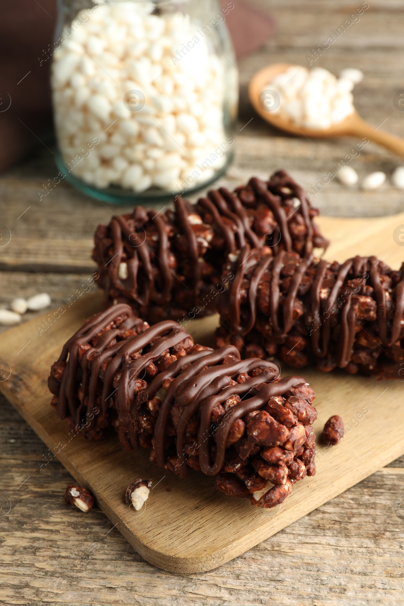 Photo of Delicious chocolate puffed rice bars on wooden table, closeup