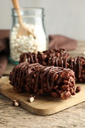 Delicious chocolate puffed rice bars on wooden table, closeup