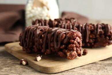 Photo of Delicious chocolate puffed rice bars on wooden table, closeup