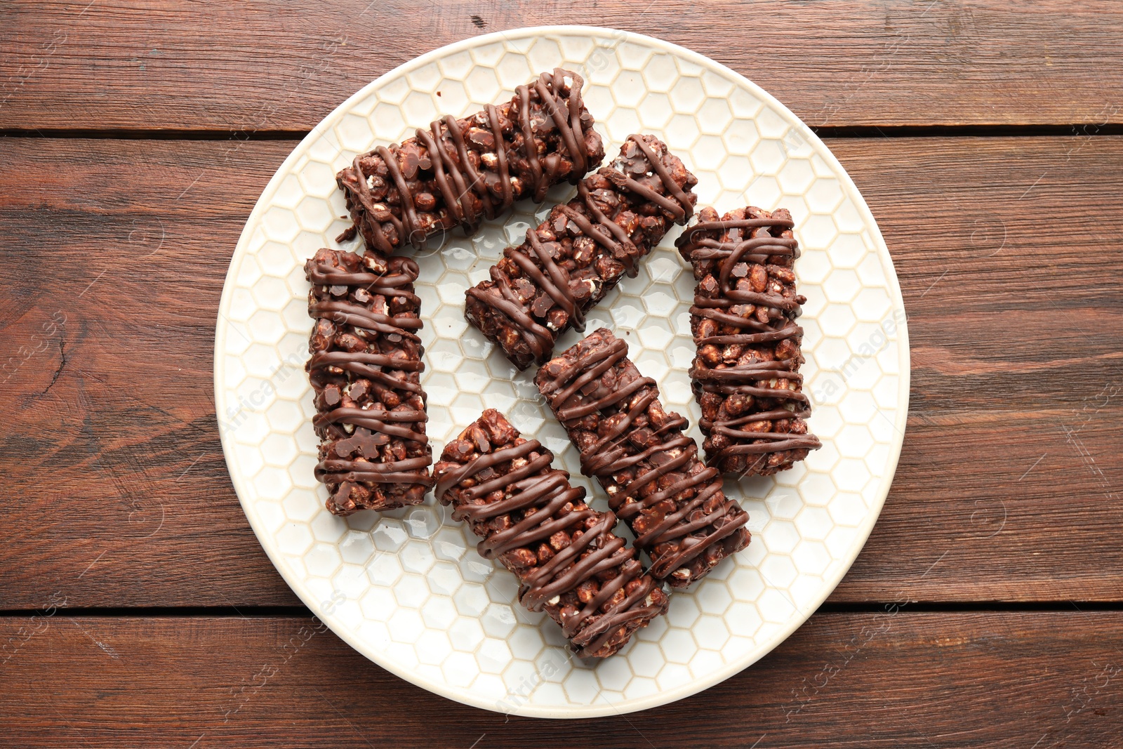 Photo of Delicious chocolate puffed rice bars on wooden table, top view