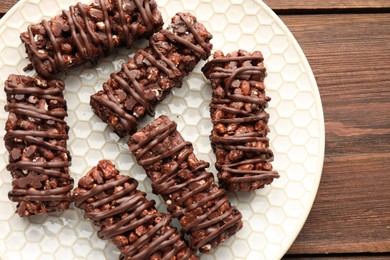 Delicious chocolate puffed rice bars on wooden table, top view