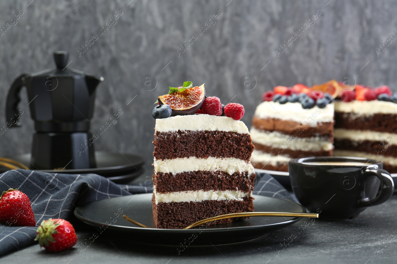 Photo of Piece of delicious chocolate sponge cake with berries and coffee on black table, closeup