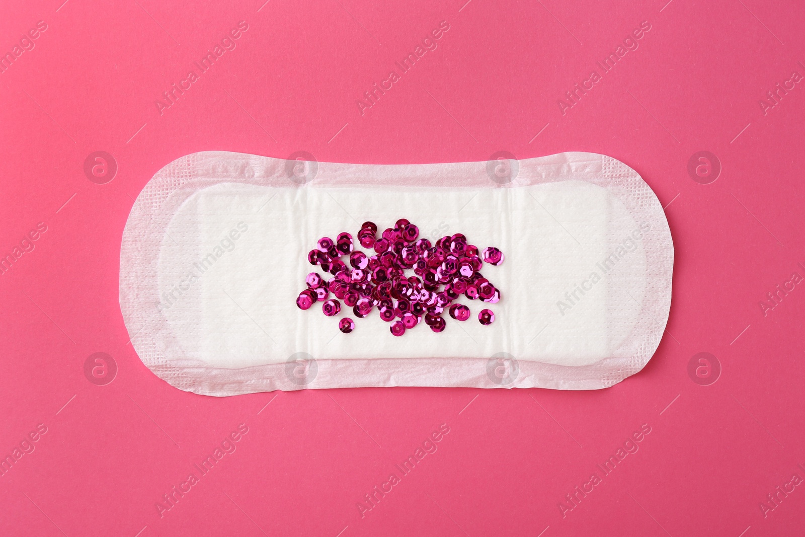 Photo of Menstrual pad with sequins on pink background, top view