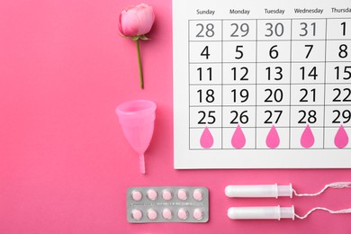 Photo of Flat lay composition with calendar and menstrual products on pink background