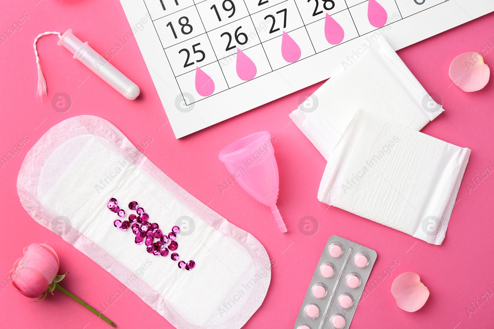 Photo of Flat lay composition with calendar and menstrual products on pink background