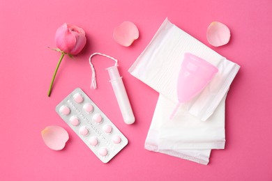 Flat lay composition with menstrual products on pink background