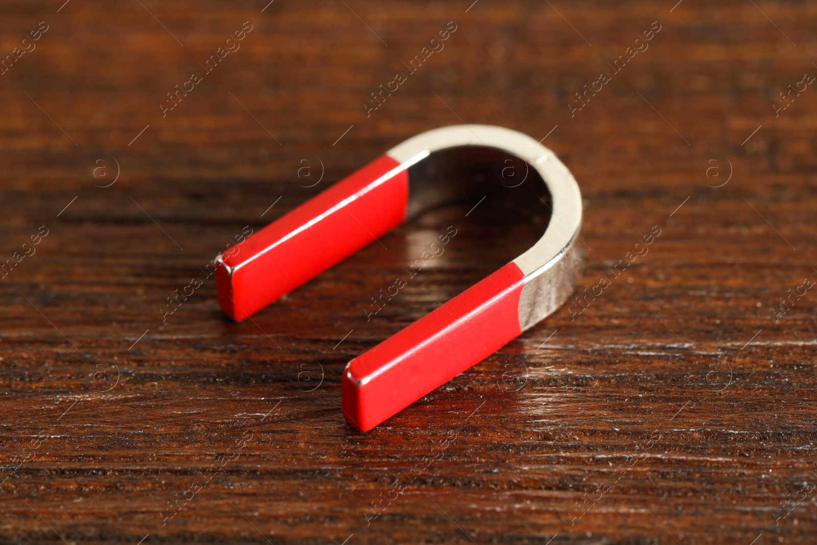 Photo of One horseshoe magnet on wooden table, closeup