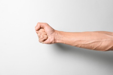 Photo of Man with bulging veins on his arm against light background, closeup