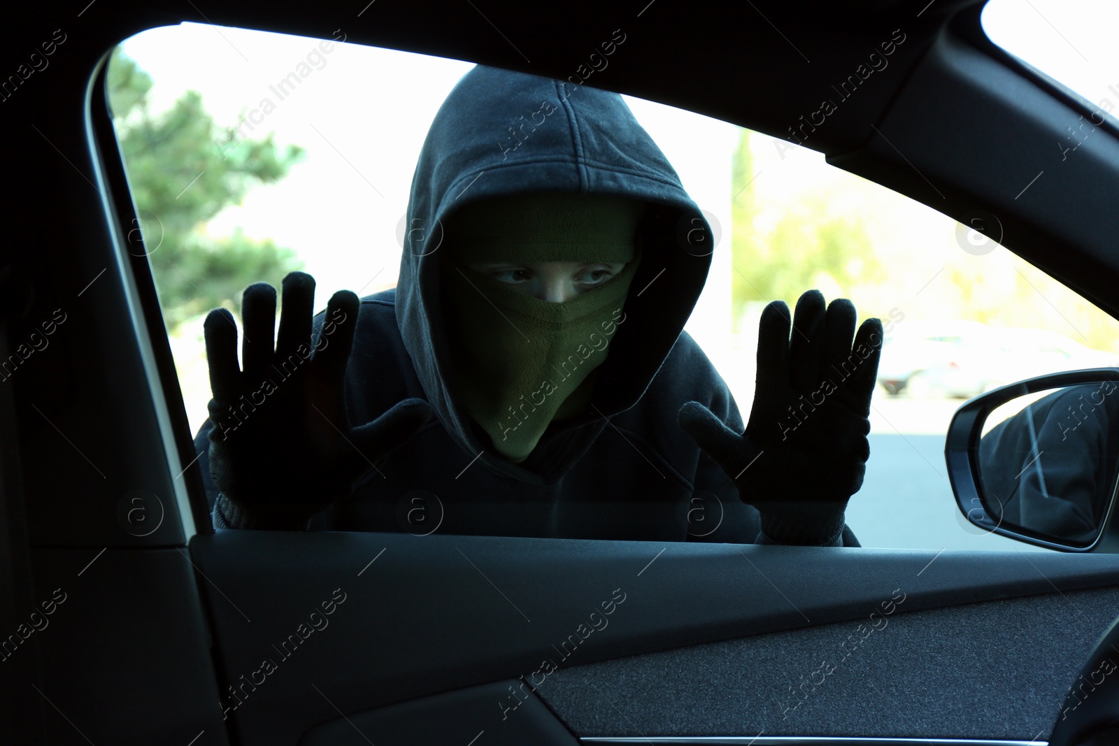 Photo of Thief looking into car through side window