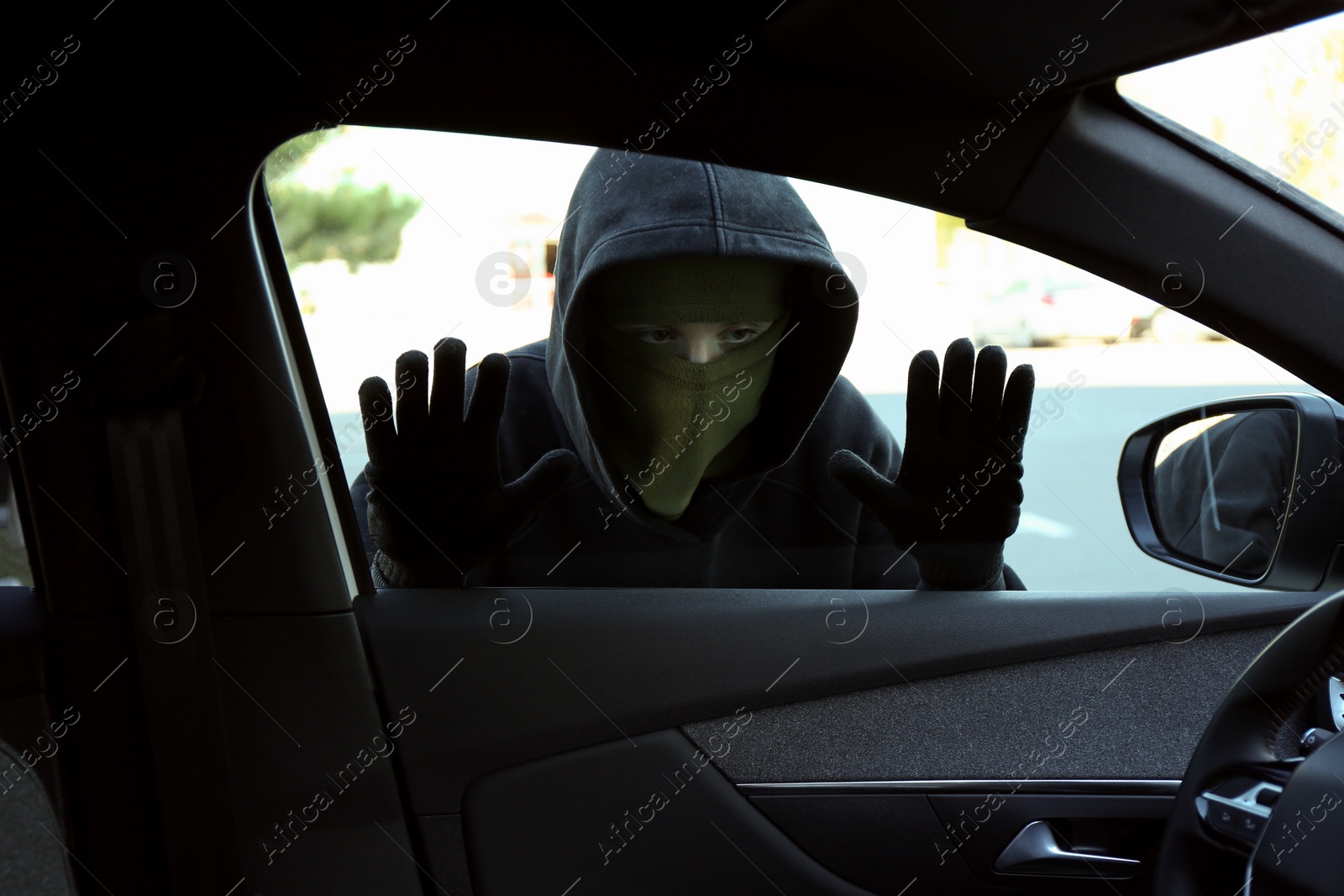 Photo of Thief looking into car through side window