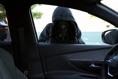 Photo of Thief looking into car through side window