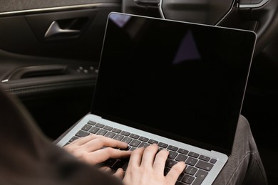 Photo of Thief hacking car system with laptop inside vehicle, closeup