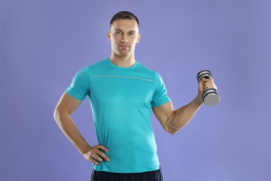 Photo of Man exercising with dumbbell on violet background