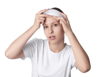 Photo of Teenage girl popping pimple on her face against white background. Acne problem