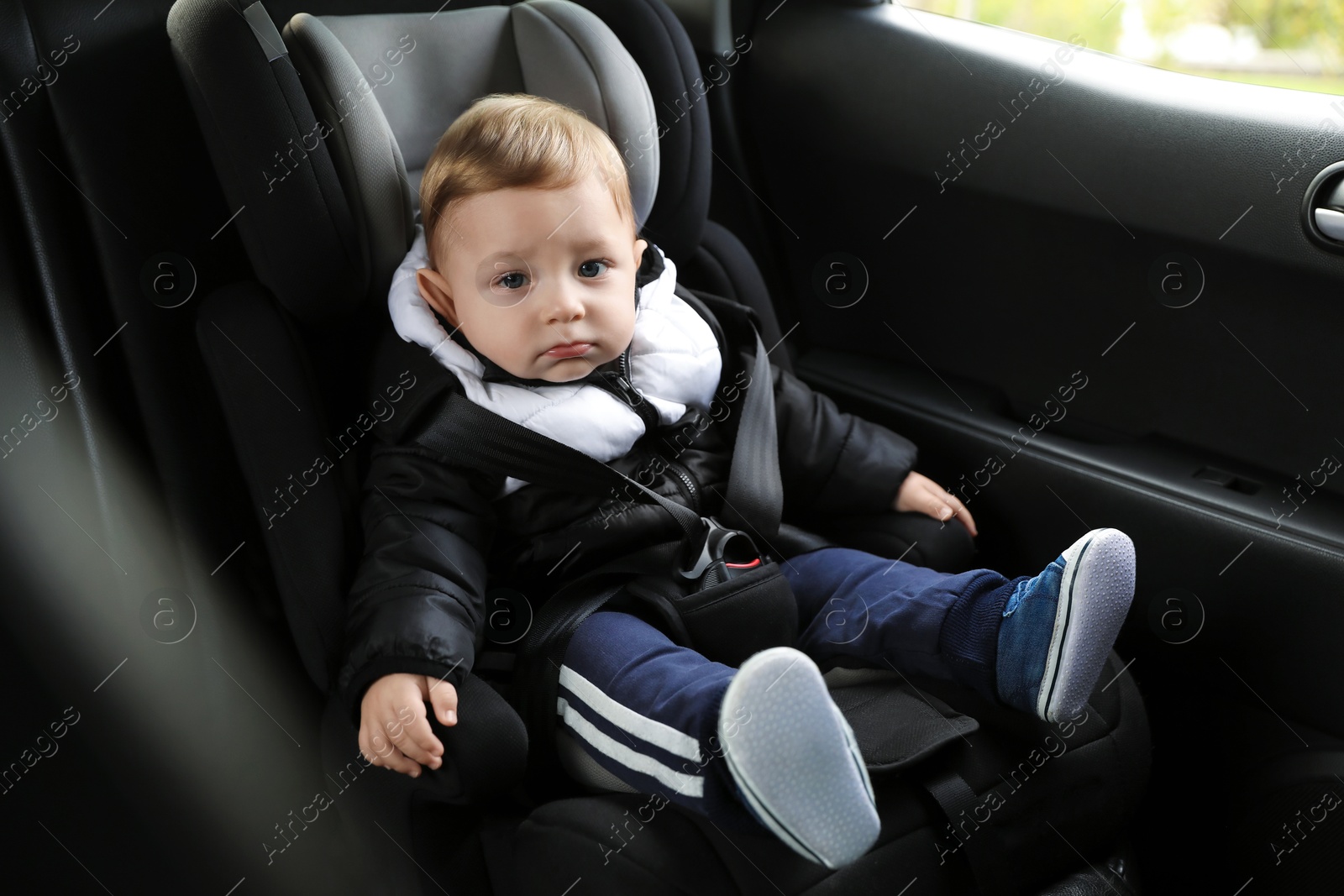 Photo of Cute little baby sitting in car seat