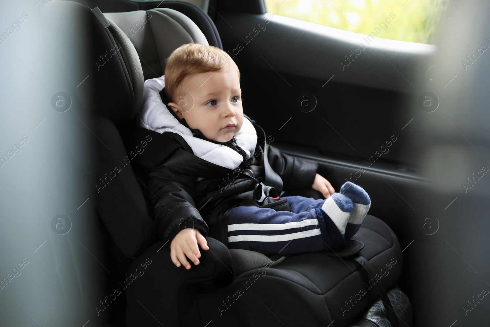 Photo of Cute little baby sitting in car seat