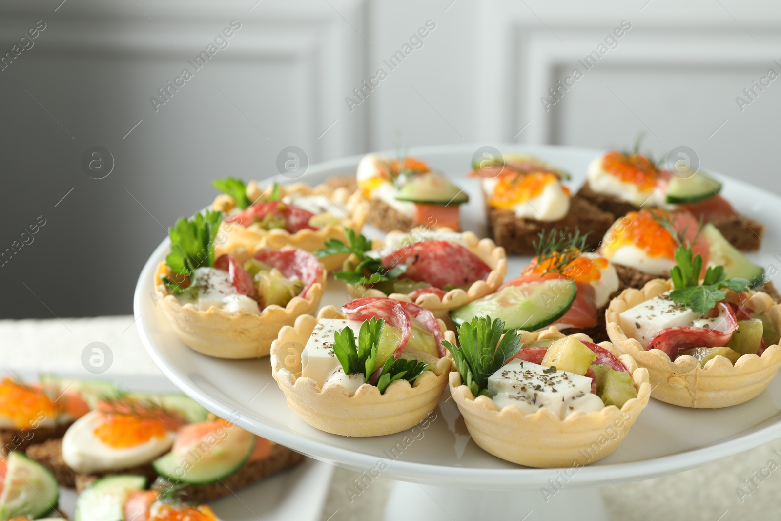 Photo of Many different tasty canapes on stand, closeup