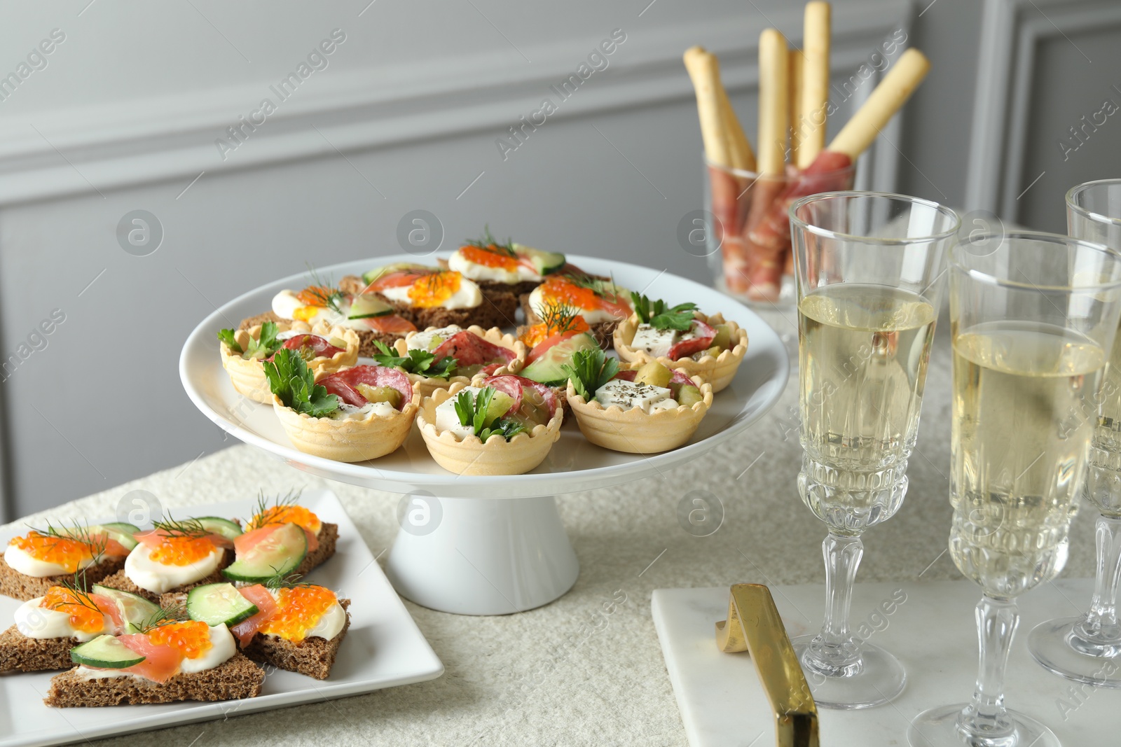 Photo of Many different tasty canapes and wine on white table