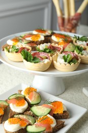 Photo of Many different tasty canapes on white table, closeup