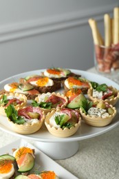 Photo of Many different tasty canapes on white table, closeup