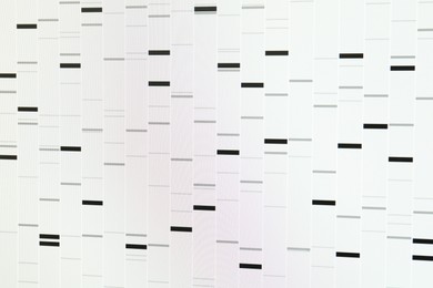 Photo of DNA analysis. Data with genetic information as background, closeup