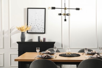 Photo of Stylish table setting with black dishware in dining room