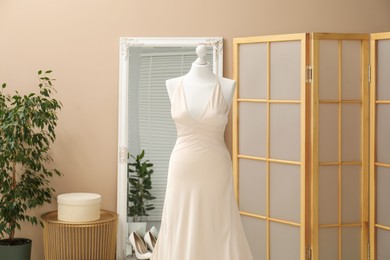 Photo of Beautiful wedding dress on mannequin in boutique