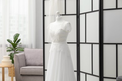 Photo of Beautiful wedding dress on mannequin in boutique