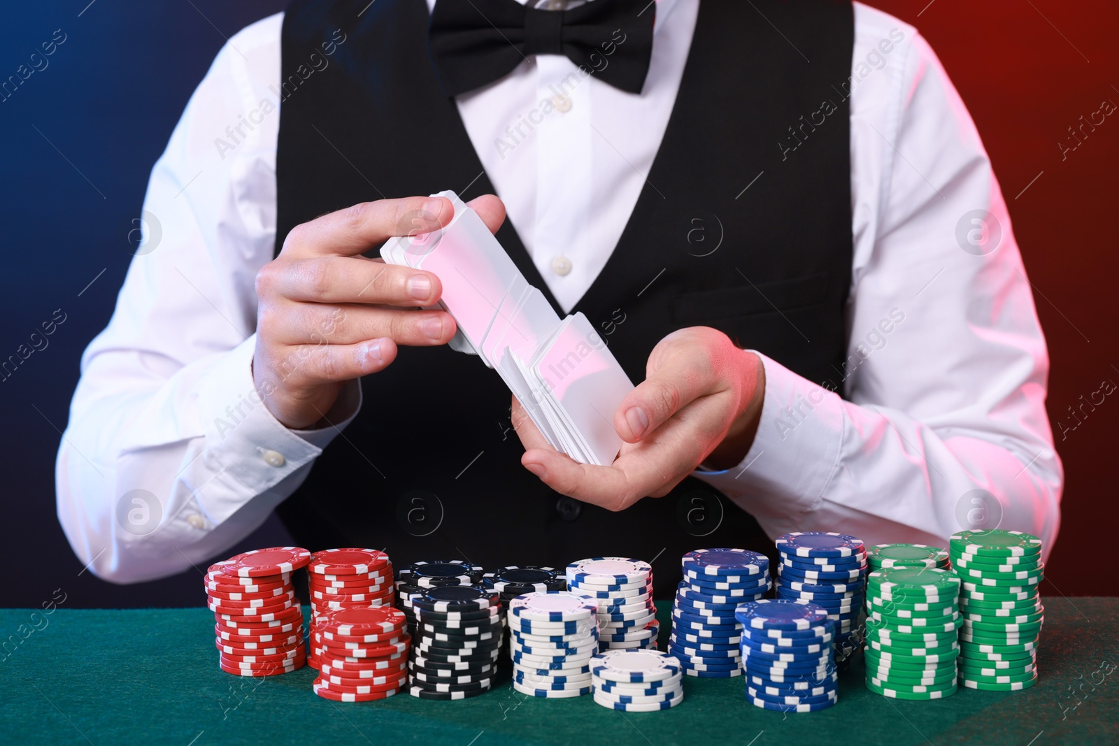 Photo of Professional croupier shuffling cards at gambling table, closeup