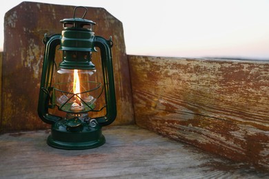 Photo of Vintage kerosene lamp in wooden boat near river at sunset