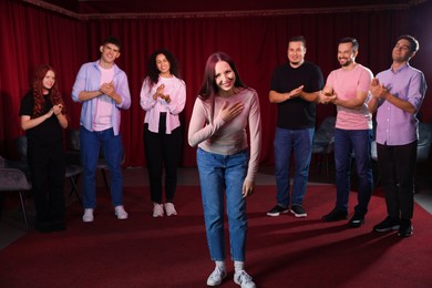 Photo of Professional actors bowing on stage in theatre