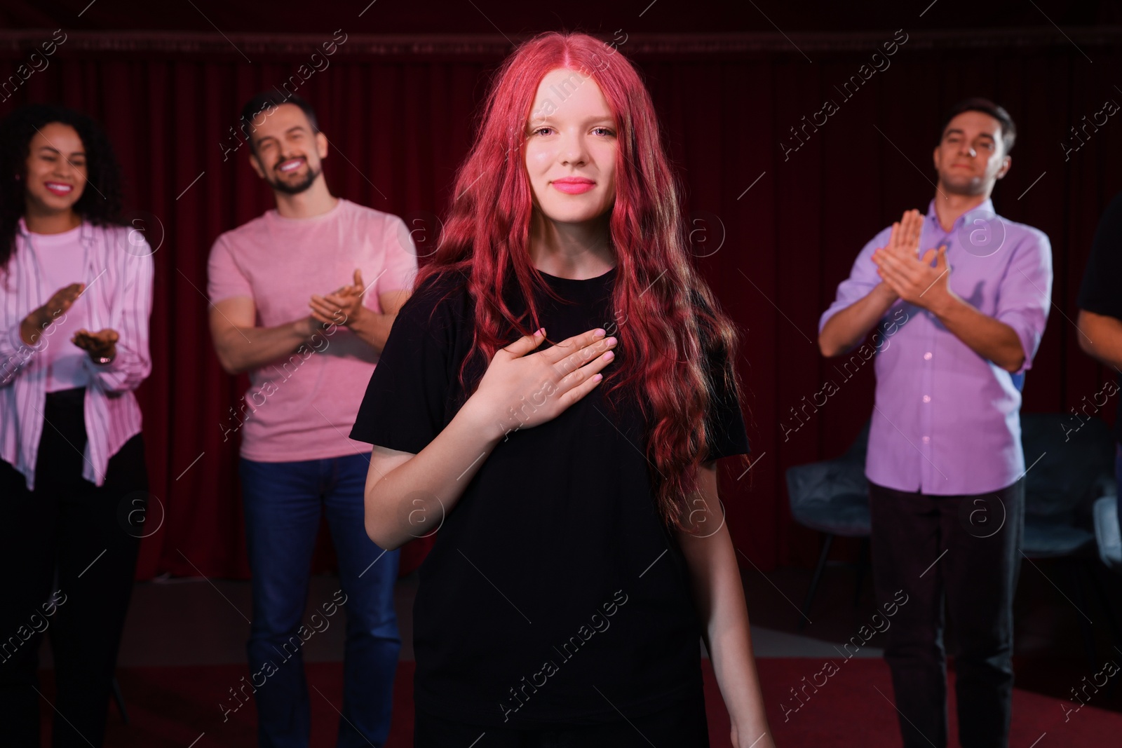 Photo of Professional actors bowing on stage in theatre