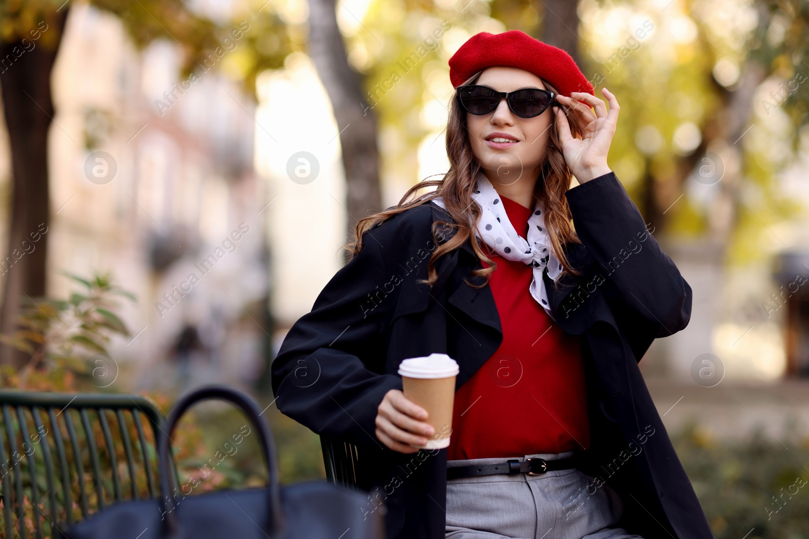 Photo of Stylish woman with cup of hot drink outdoors